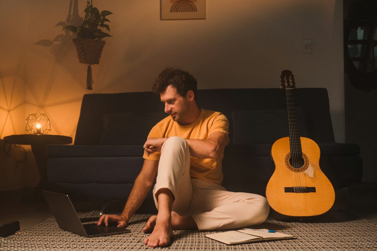 young man sitting on floor with cardboard box and laptop discouraged.jpg