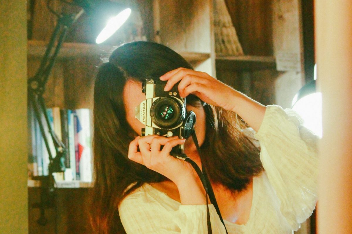young woman photographing vintage mirror